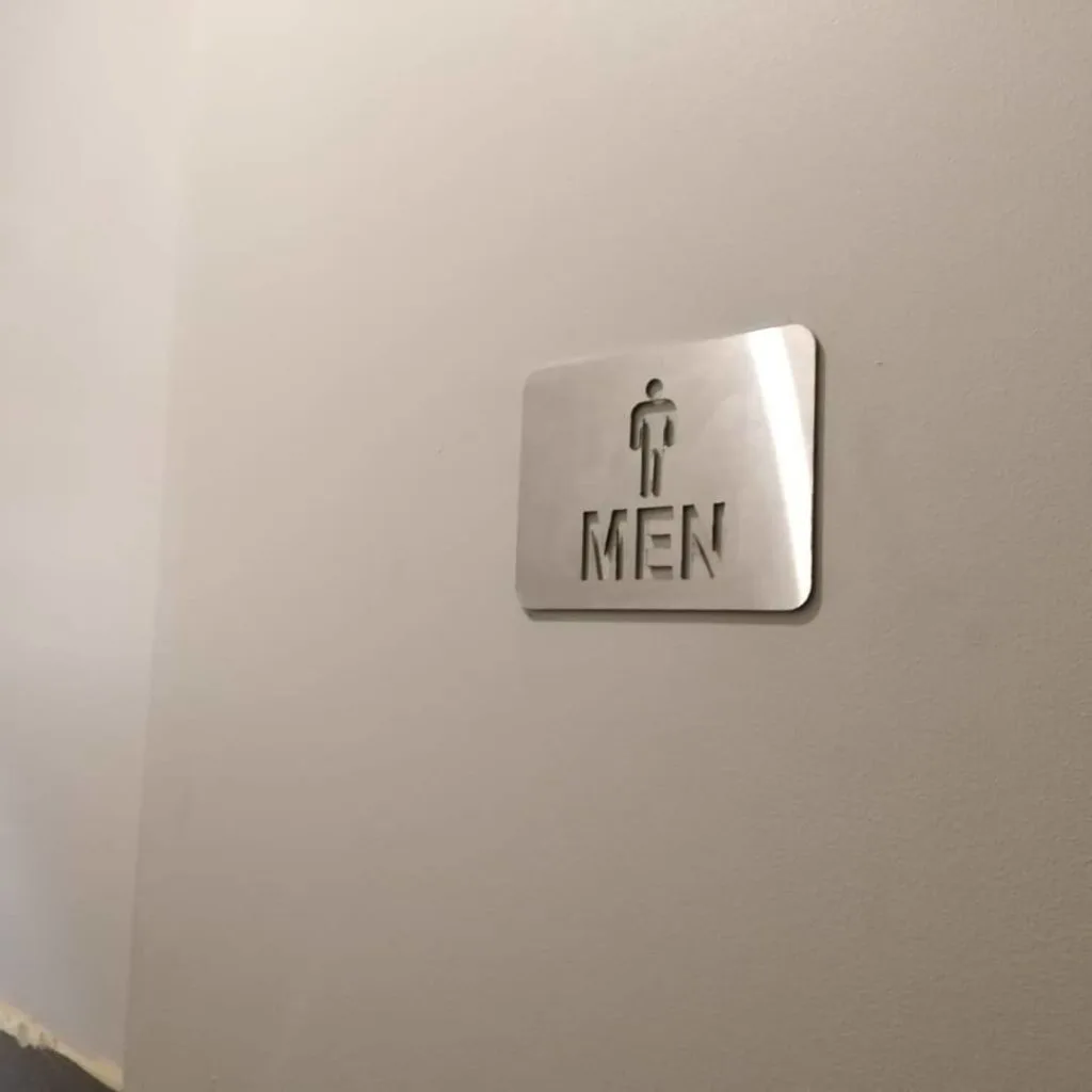 Men's restroom sign mounted on an interior wall