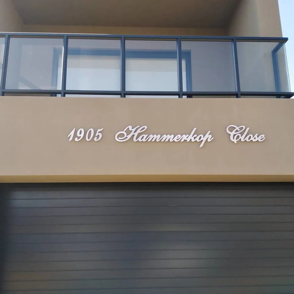 Custom address lettering above a residential garage door
