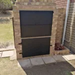 Custom metal door installed at a brick building entrance