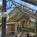 Steel roof trusses beneath a partially covered structure