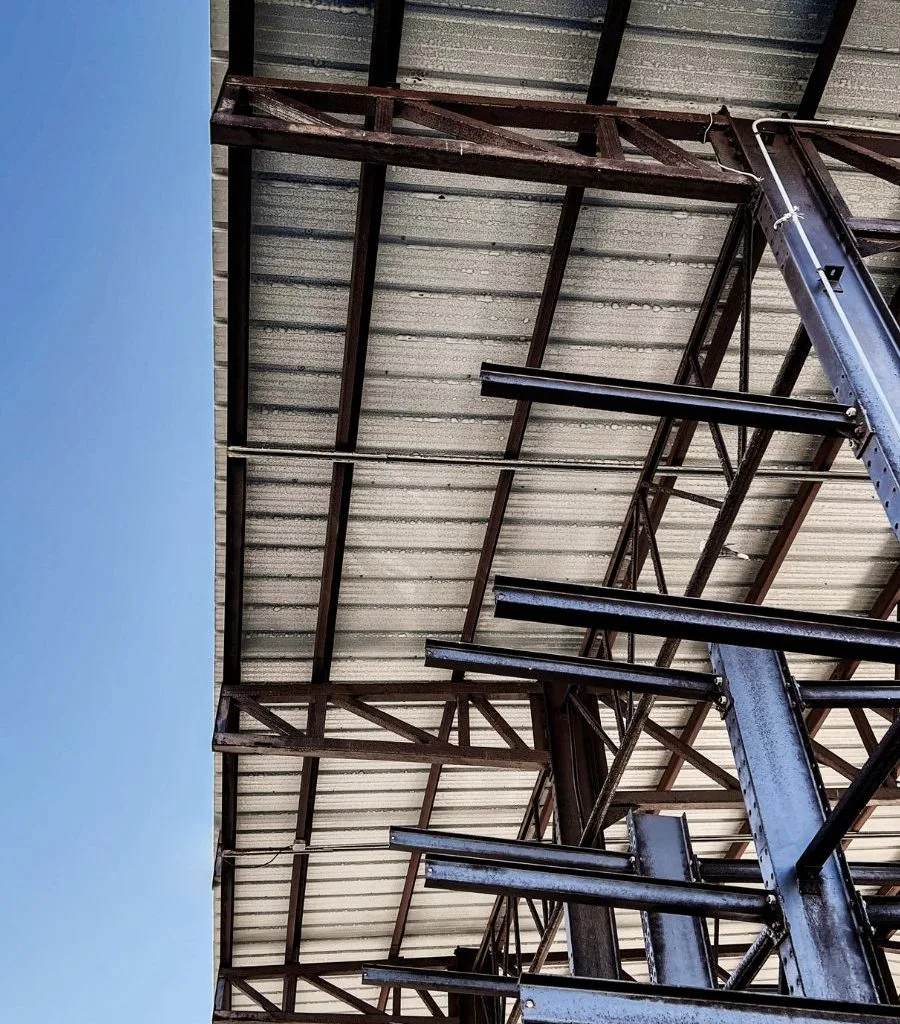 Steel roof framing viewed from beneath a building canopy