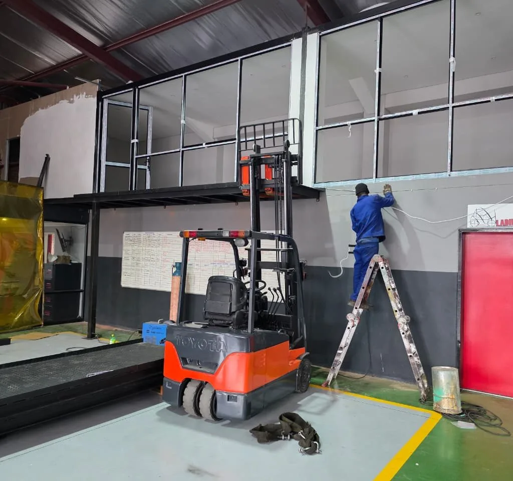Mezzanine installation work beside warehouse access equipment