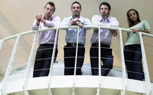 People standing behind a balcony safety railing